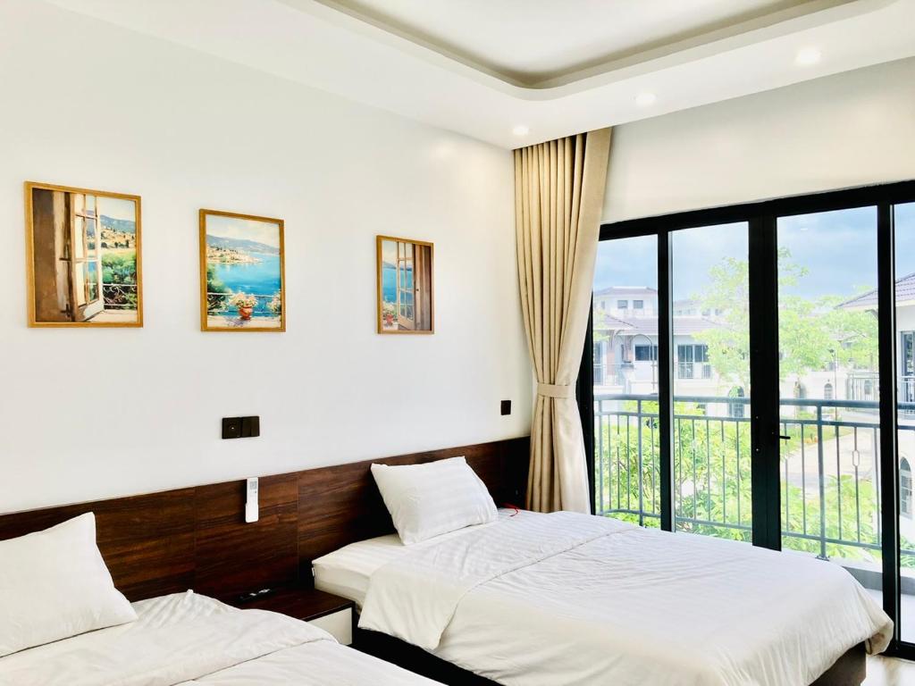 - 2 lits dans une chambre avec fenêtre dans l'établissement V3E02 Dahlia villa - khu nghỉ dưỡng Sonasea Vân Đồn, à Cái Rồng