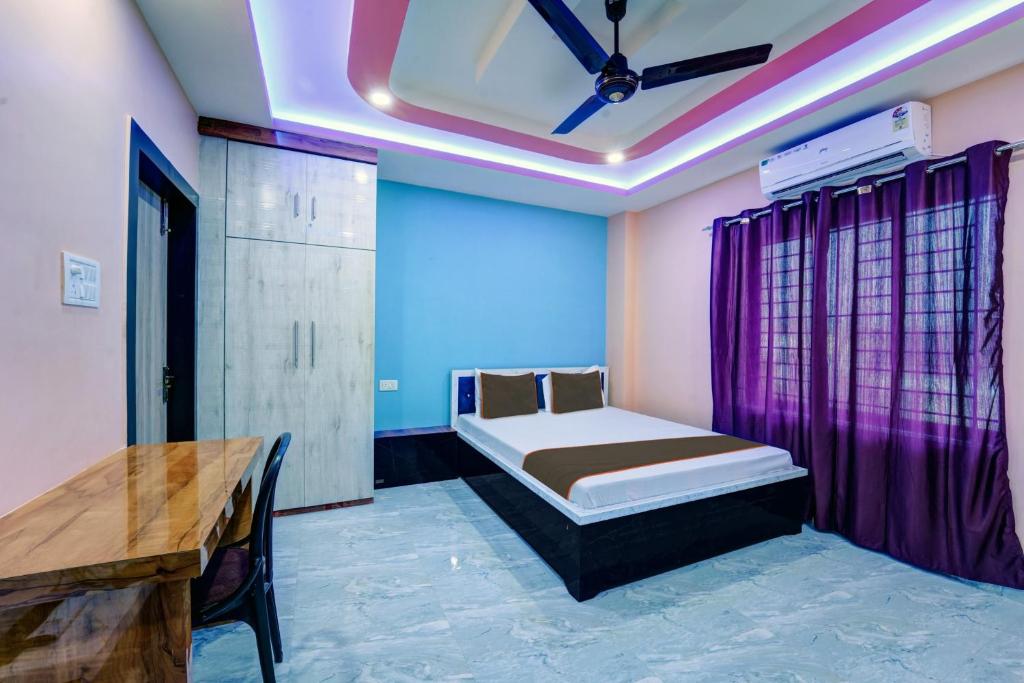 1 dormitorio con 1 cama con cortinas moradas y mesa en Hotel Rl & Banquet Hall, en Guwahati