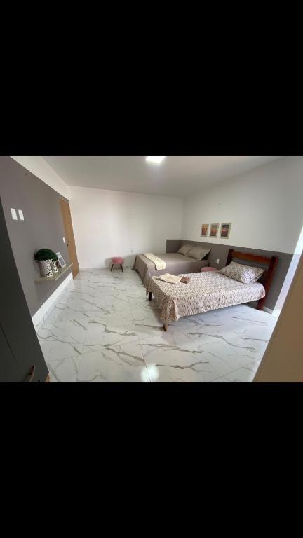 Viçosa Flat في فيسوزا دو سيارا: غرفة معيشة بها سريرين وأريكة
