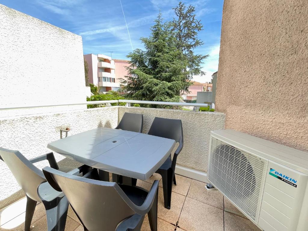 d'une table et de chaises sur un balcon avec chauffage. dans l'établissement Appartement climatisé à Sète avec parking privé, proche plages et commodités - FR-1-338-570, à Sète