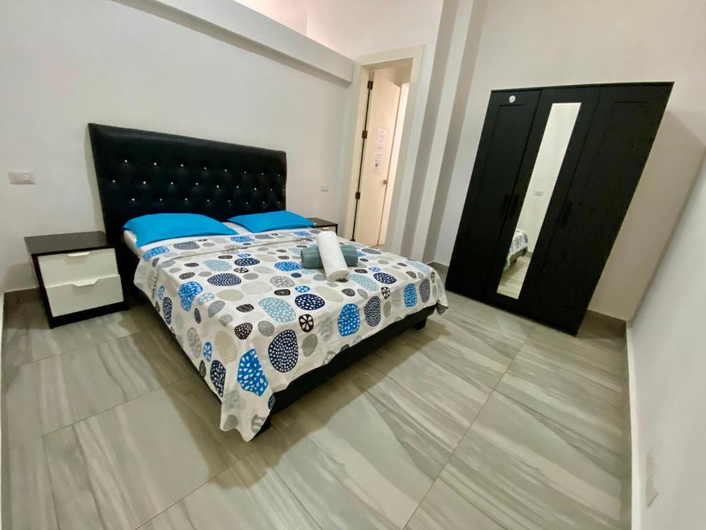 a bedroom with a bed with a blue and white comforter at cozy apartment near the beach los corales punta Cana. in Punta Cana