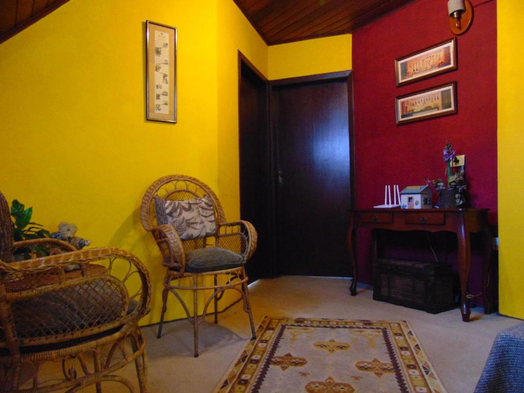 a room with two chairs and a door and a table at Pousada Refúgio Akatu in Campos do Jordão