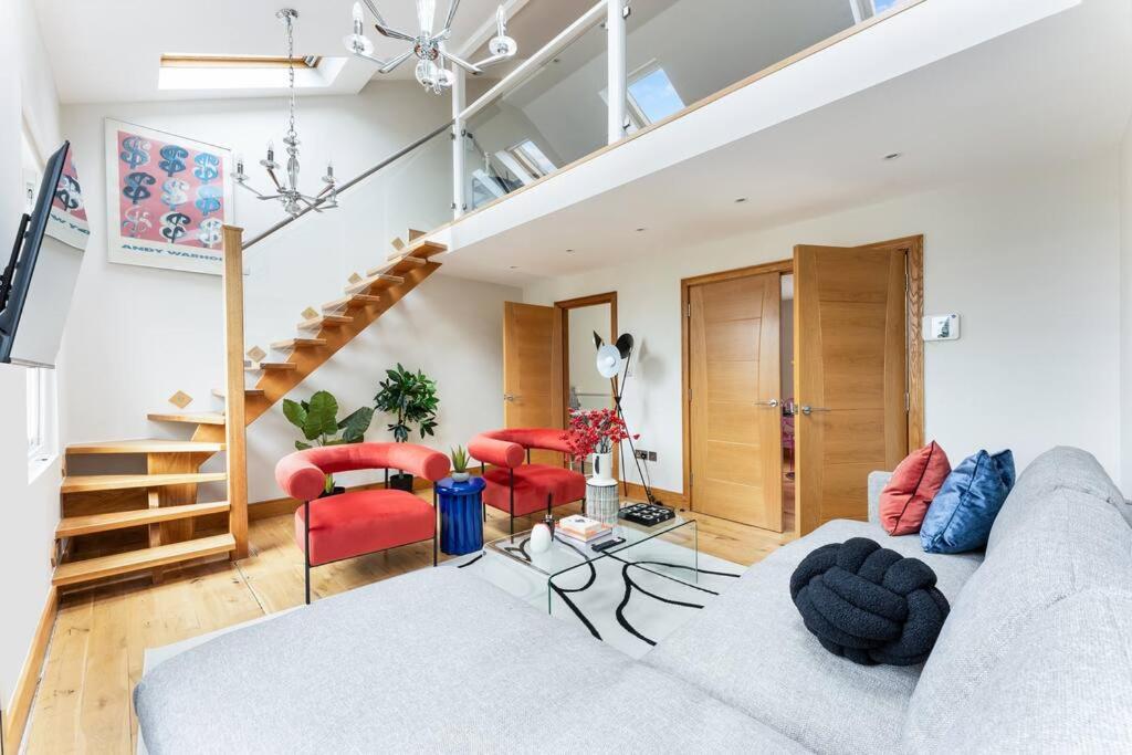 sala de estar con sofá y sillas rojas en Vibrant Urban Escape, Family Friendly - Sleeps 8!, en Londres