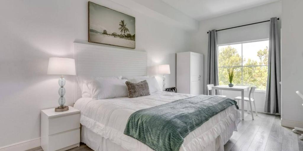 Un dormitorio blanco con una cama grande y una ventana en King Bed Studio Near Disney, en Orlando