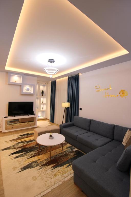 a living room with a couch and a table at Sarande Luxury Central apartment Reni Risi in Sarandë