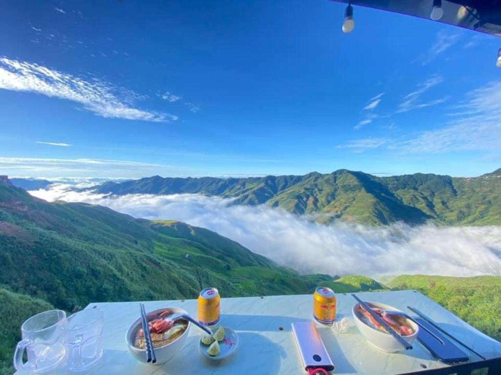 un tavolo con cibo in cima a una montagna di Mây House – Sống Lưng Khủng Long a Bắc Yên