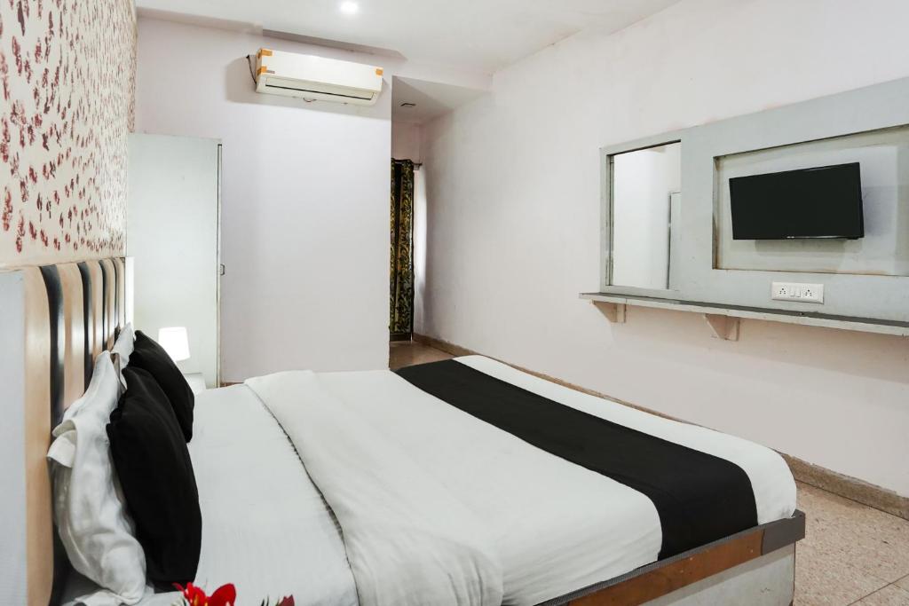فندق كريستال في أحمد آباد: غرفة نوم بسرير وتلفزيون على جدار