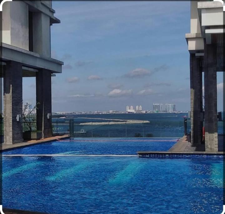 a large swimming pool with a view of the water at Ancol mansion apartement in Jakarta