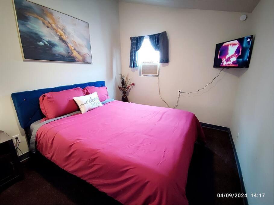 a bedroom with a bed with a pink blanket at Zen Haven 5- Close to Downtown Indy- Queen Bed in Indianapolis