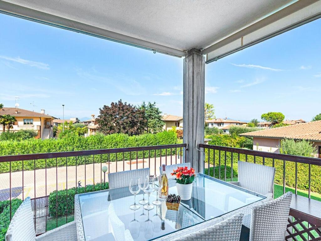 a patio with a glass table and chairs on a balcony at Lugana Point Comfortable holiday residence in Sirmione