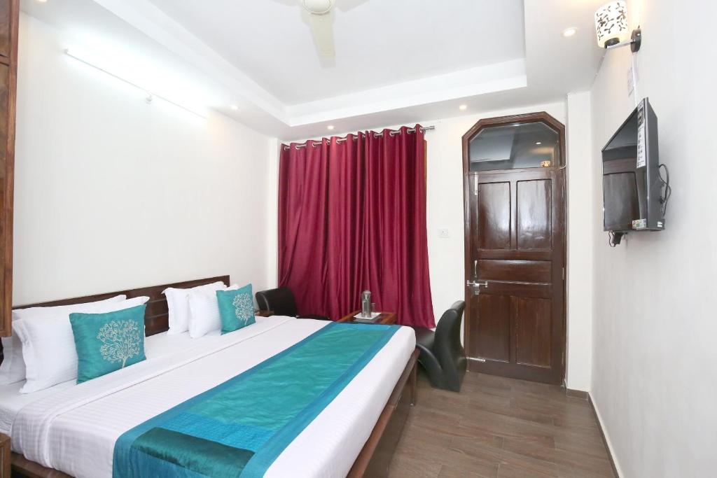 um quarto de hotel com uma cama e uma televisão em OYO Hotel Sai Stay Inn em Chhota Simla
