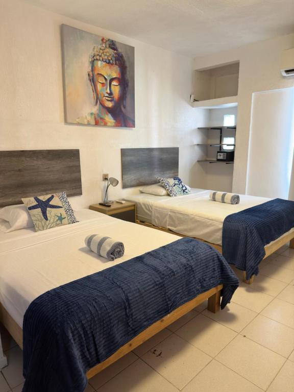 a hotel room with two beds and a painting on the wall at Suites Brisa Marina - Playa Regatas y Malecón in Veracruz