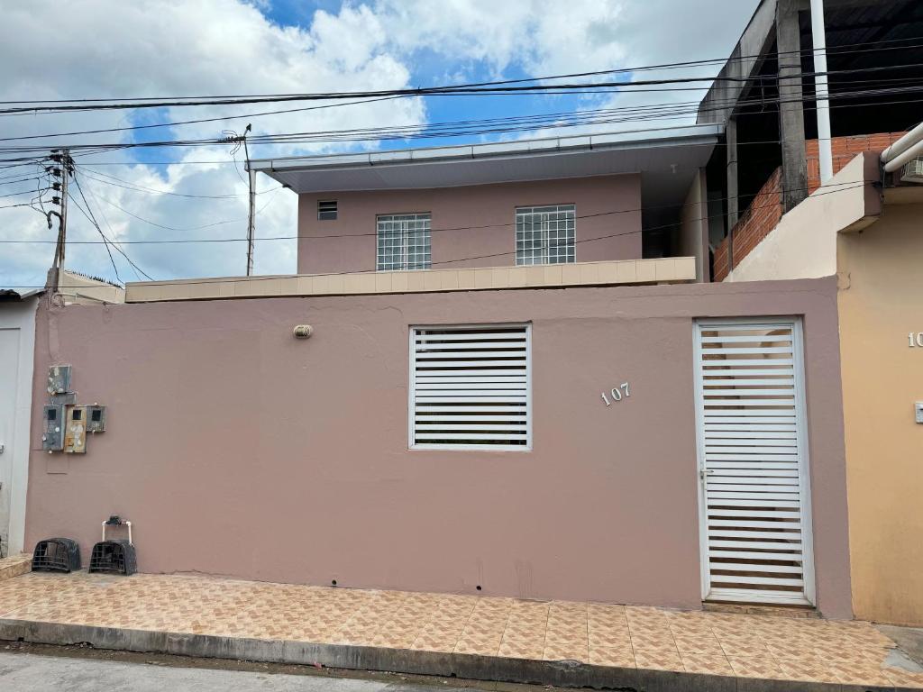 Una casa rosa con dos puertas de garaje. en Apt com ótima localização, com Wi-fi, próximo do Shopping e Aeroporto en Manaos