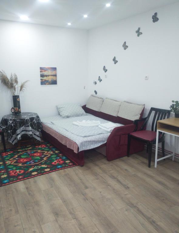 um quarto com uma cama, uma mesa e uma cadeira em Reteganu Apartment em Dej