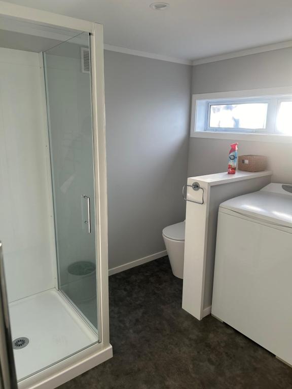 ein Bad mit einer Duschkabine und einem WC in der Unterkunft Team Mac Homestay in Rotorua