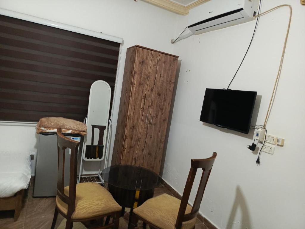 ジャラシュにあるJerash ruins hotelのテーブル、椅子、テレビが備わる客室です。