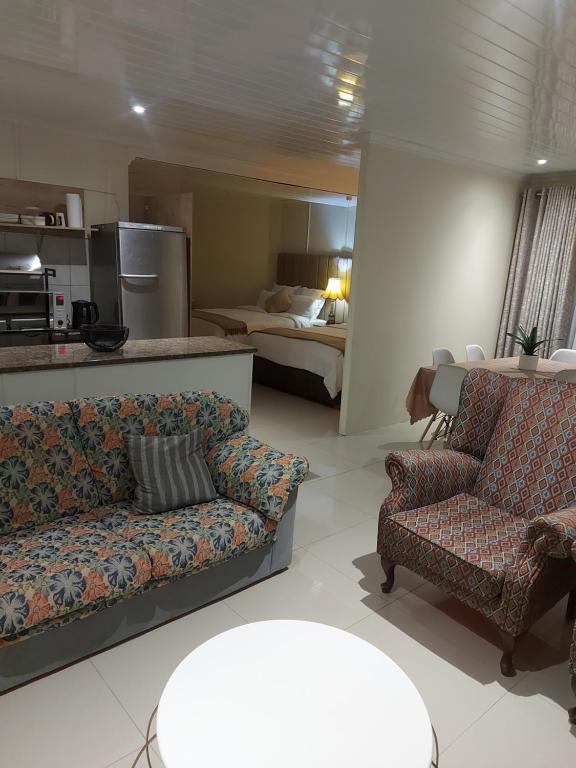 salon z 2 kanapami i sypialnią w obiekcie Purple Olive Guest House w mieście Pretoria