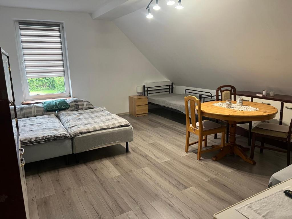a room with a table and a bed and a table and chairs at Pokoje na wsi in Bukowina