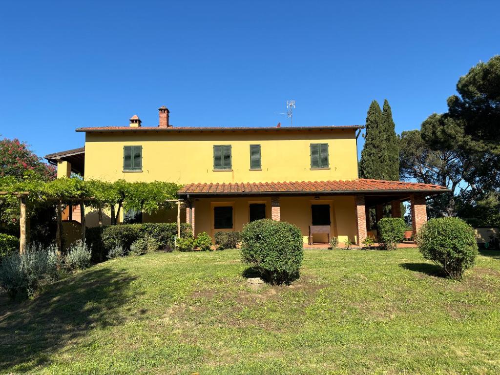 ein großes gelbes Haus mit Büschen im Hof in der Unterkunft Villa Olea in SantʼEllero