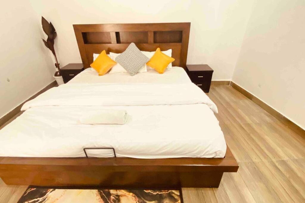 a bedroom with a large bed with yellow pillows at Beautiful Ganga side villa in Rishīkesh