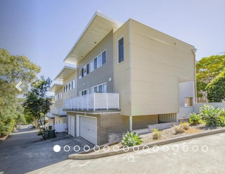 a apartment building with a parking lot in front of it at Furnished Home near Newcastle and Warners Bay in Mount Hutton