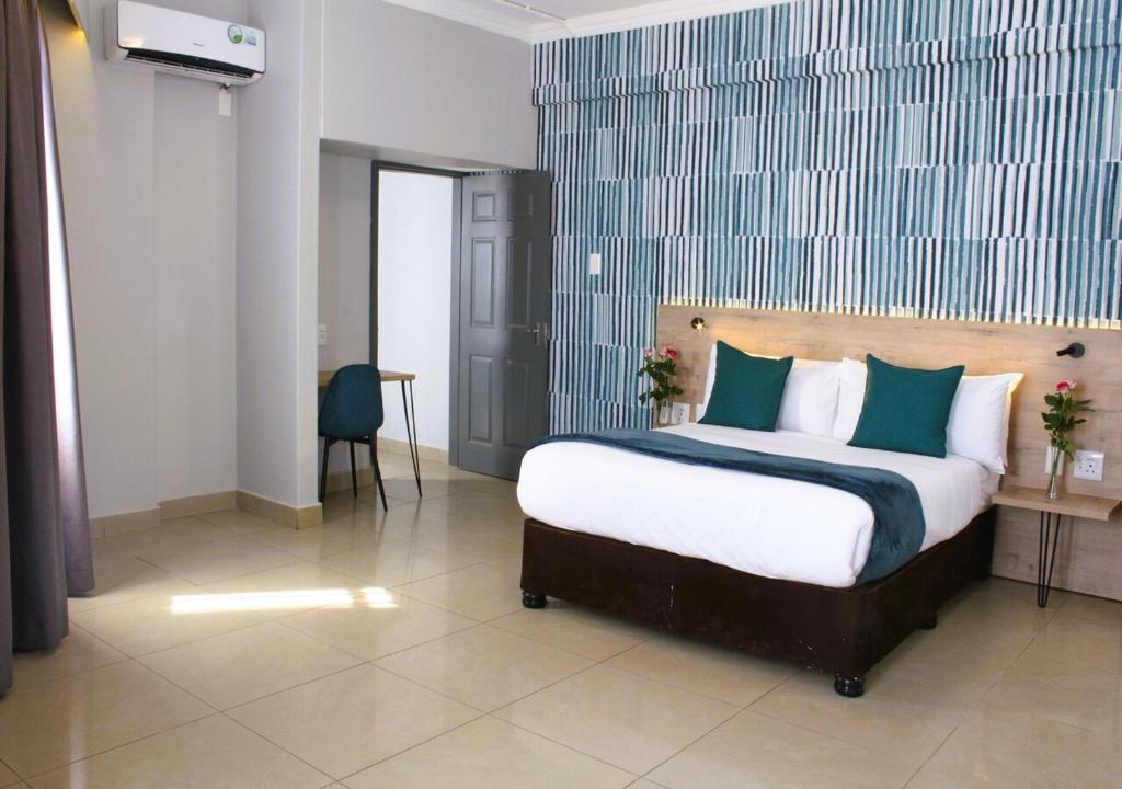 Bayside Hotel 14 Monty Naicker(Pinestreet) في ديربان: غرفة نوم بسرير كبير مع وسائد زرقاء