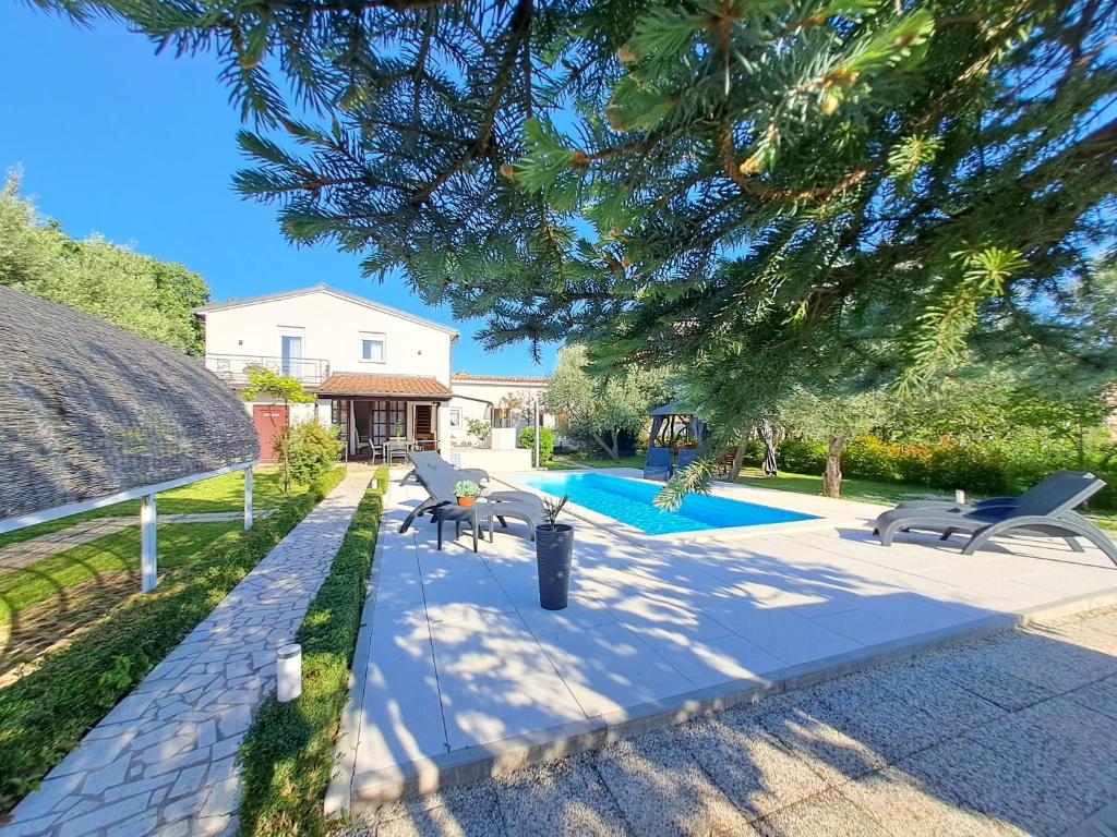 a backyard with a swimming pool and a house at Villa Grace Felice in Fažana