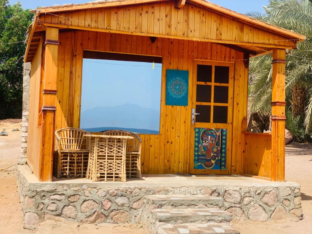 un capannone in legno con una grande finestra e una porta di New Mabroka a Nuweiba