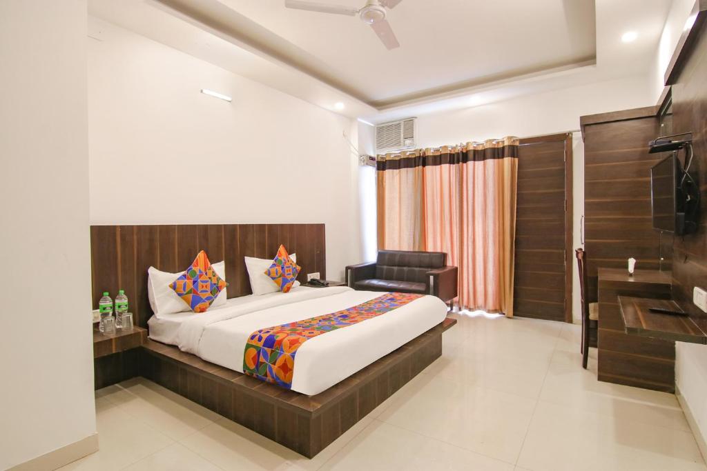 a bedroom with a large bed and a bathroom at FabExpress Ero sky Palace in New Delhi