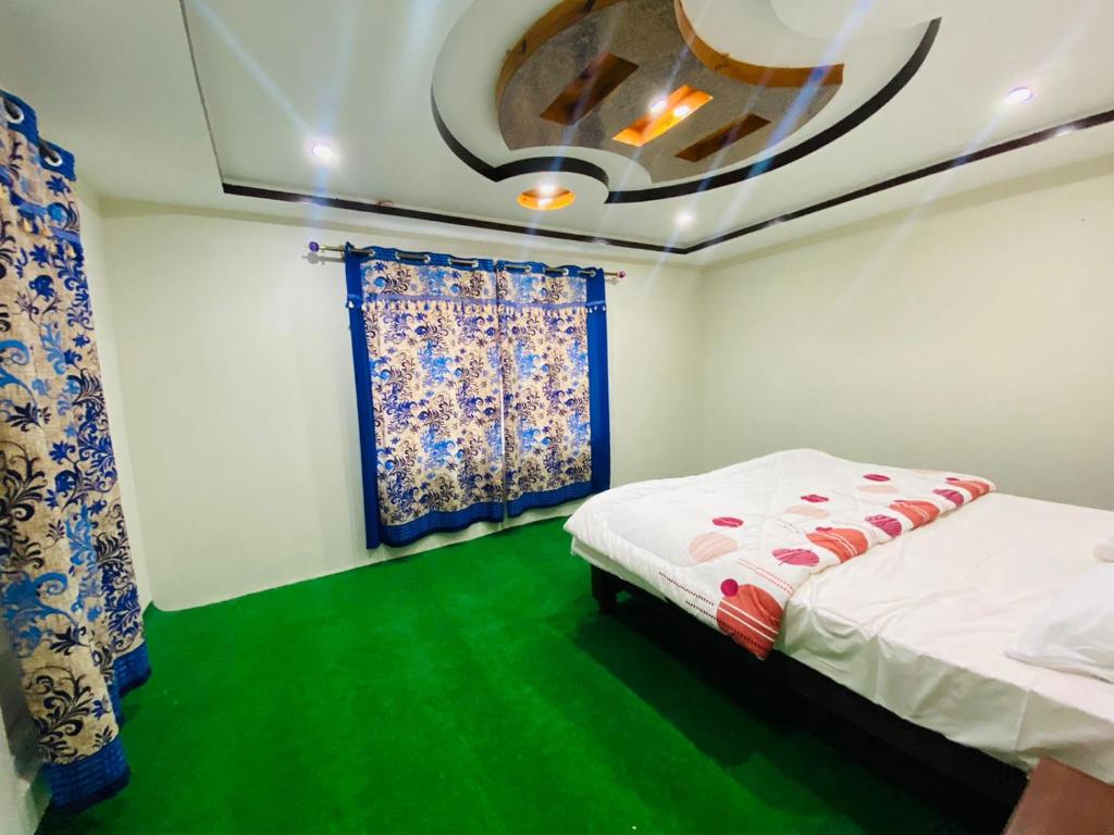 sypialnia z 2 łóżkami i zieloną podłogą w obiekcie Skardu One Resort w mieście Skardu