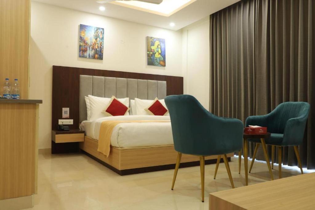 a hotel room with a bed and two chairs at Hotel Krone Plaza IGI Airport Delhi in New Delhi