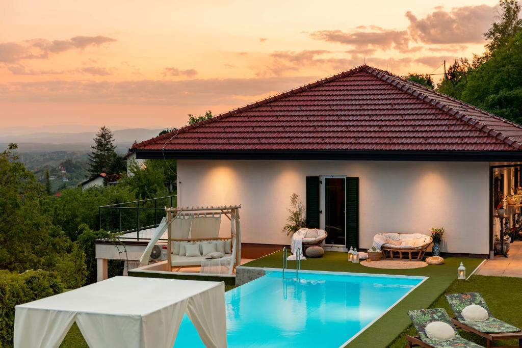 a villa with a swimming pool in front of a house at Villa Plešivica view - Infinity Pool & Private Spa in Plešivica