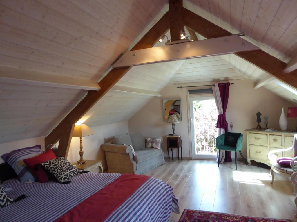 an attic bedroom with a bed and a couch at Location Ker Bihan in Saint-Lunaire