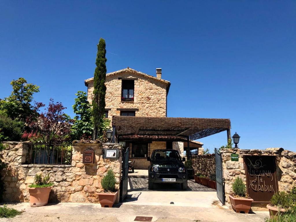 a car parked in front of a stone building at Casa Rural Las Tainas de Carabias in Carabias