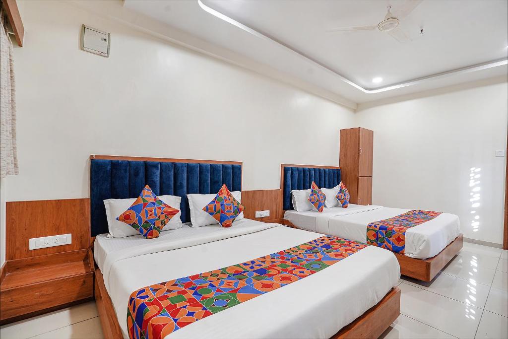 two beds in a hotel room with at FabHotel HK Villa in Vadodara