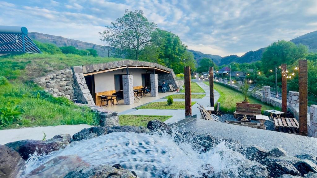 una fontana di fronte a un piccolo edificio di Hotel Hobbiton near Vardzia Caves a T'mogvi