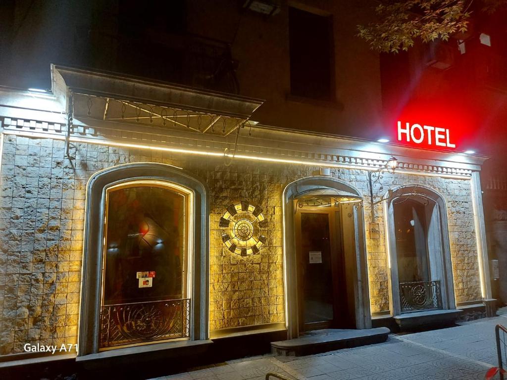 una señal de hotel en el lateral de un edificio por la noche en Hotel Jan & in the very center en Ereván