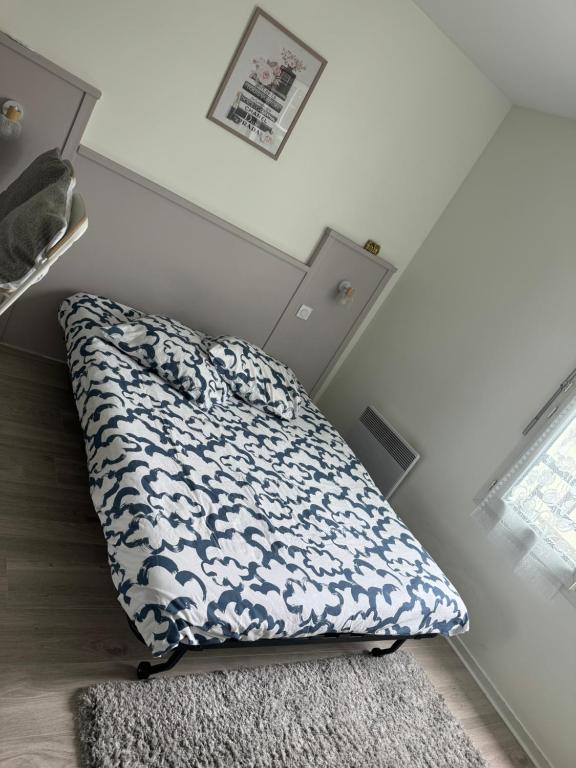 - un lit dans une chambre avec un oreiller et un tapis dans l'établissement Studio Antony centre équipé Wifi, 7minutes à pieds Gare Antony avec RER B , Orlyval, à Antony