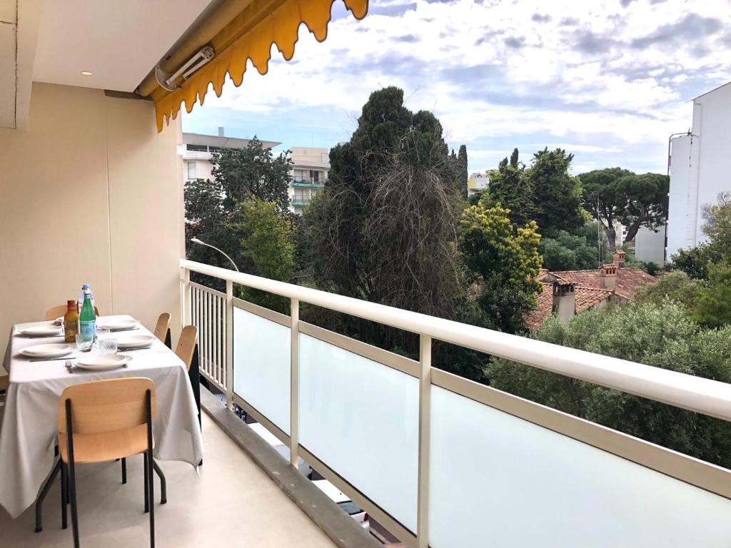 d'un balcon avec une table et une vue sur les arbres. dans l'établissement Ref HELV Palmes dProperties, à Cannes