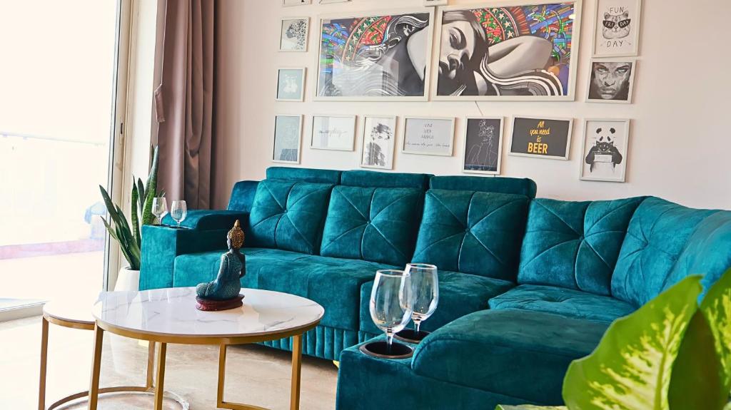 Stylish 3BHK Penthouse W/Terrace Steps from EON IT في بيون: غرفة معيشة مع أريكة زرقاء وطاولة