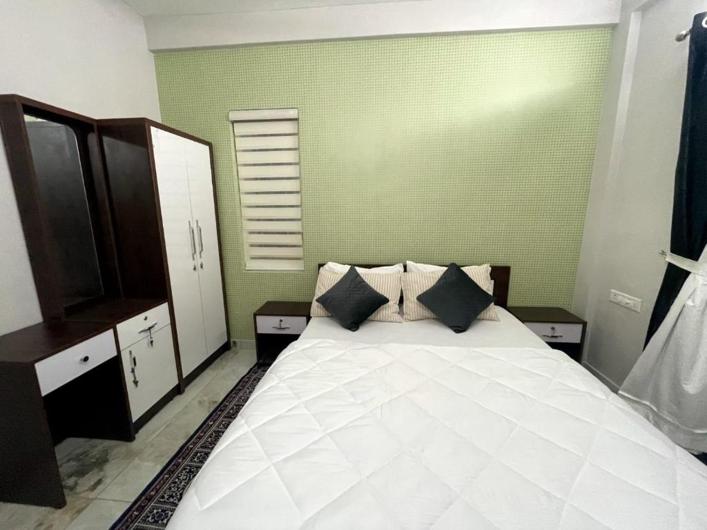 a bedroom with a large white bed with two pillows at Blue core in Ernakulam