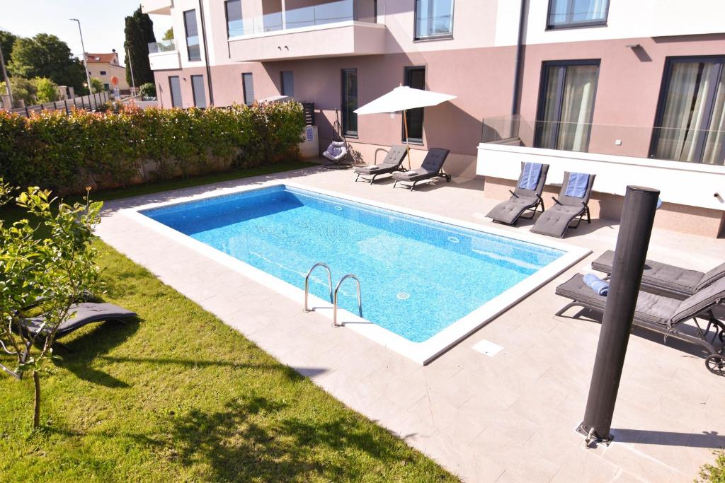 una piscina en el patio trasero de una casa en Luxury apartment Grotta with sea view and swimming pool en Premantura