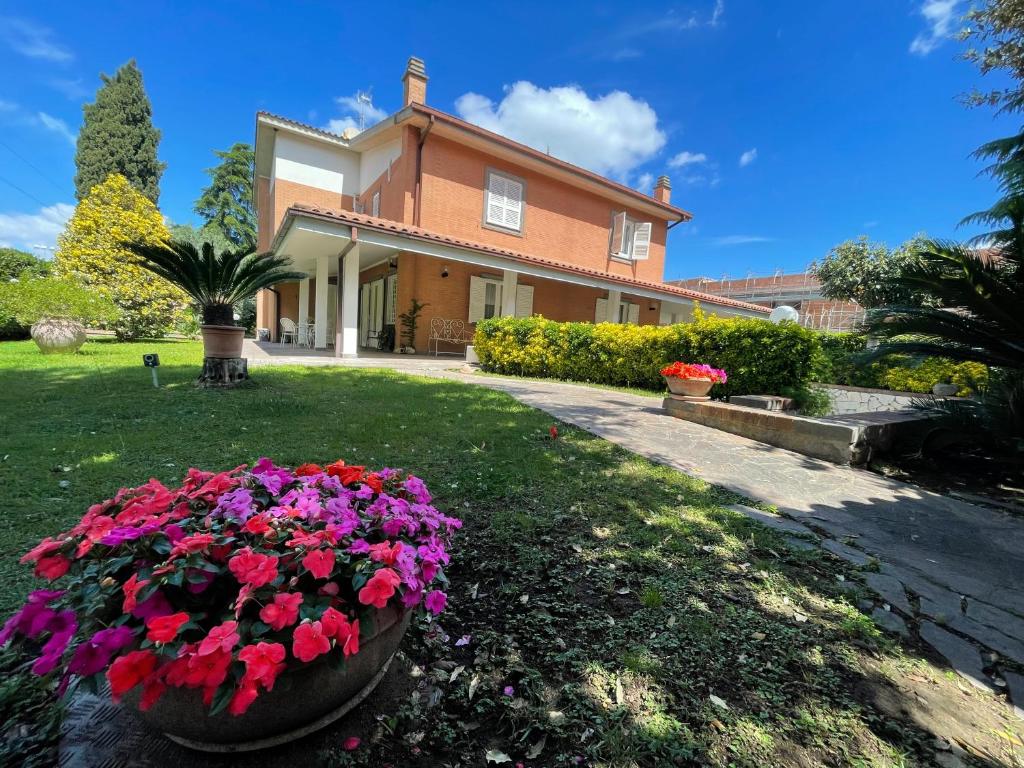 a large house with flowers in the yard at Inn Rome B&B in Ciampino