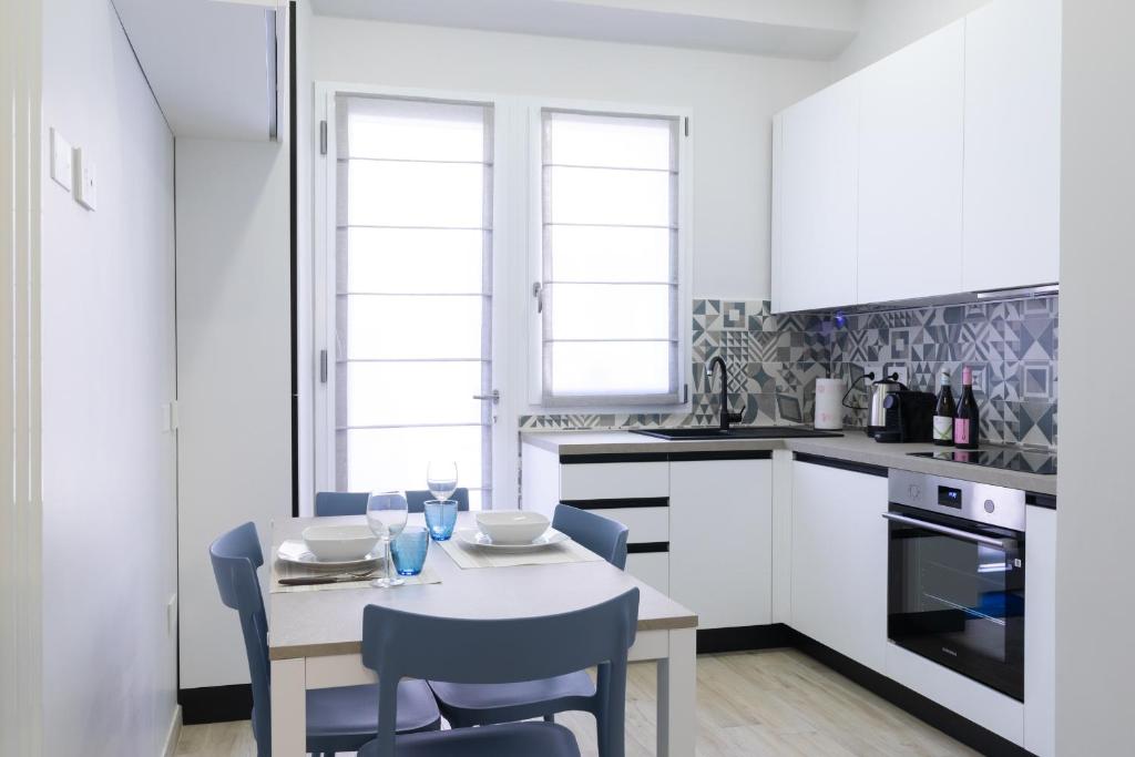 a white kitchen with a table and chairs in it at Cairoli Lifestyle in Fano