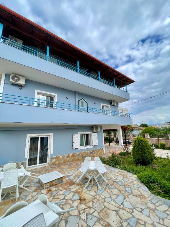 un edificio con sedie bianche e un patio di Vila Elite a Ksamil