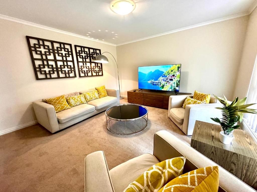 uma sala de estar com sofás e uma televisão de ecrã plano em Adelaide Hills 4 bed home near Hahndorf Mt Barker 