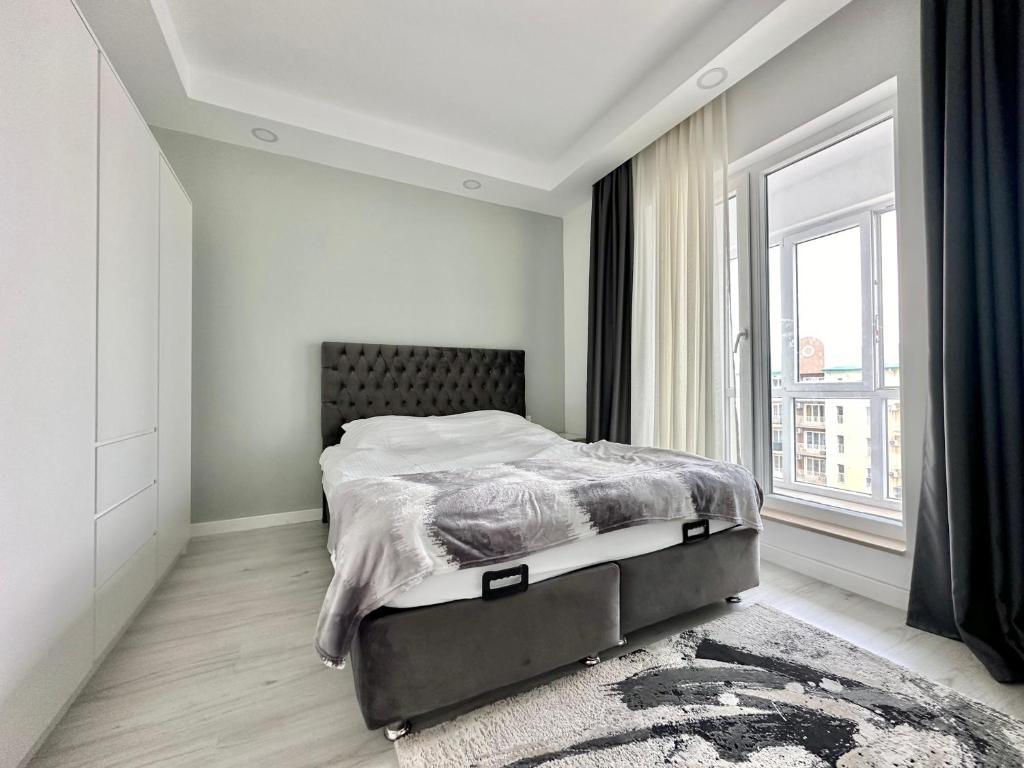 a bedroom with a bed and a large window at Double Studio B601 StayInn by Cosmopolis in Ştefăneştii de Jos