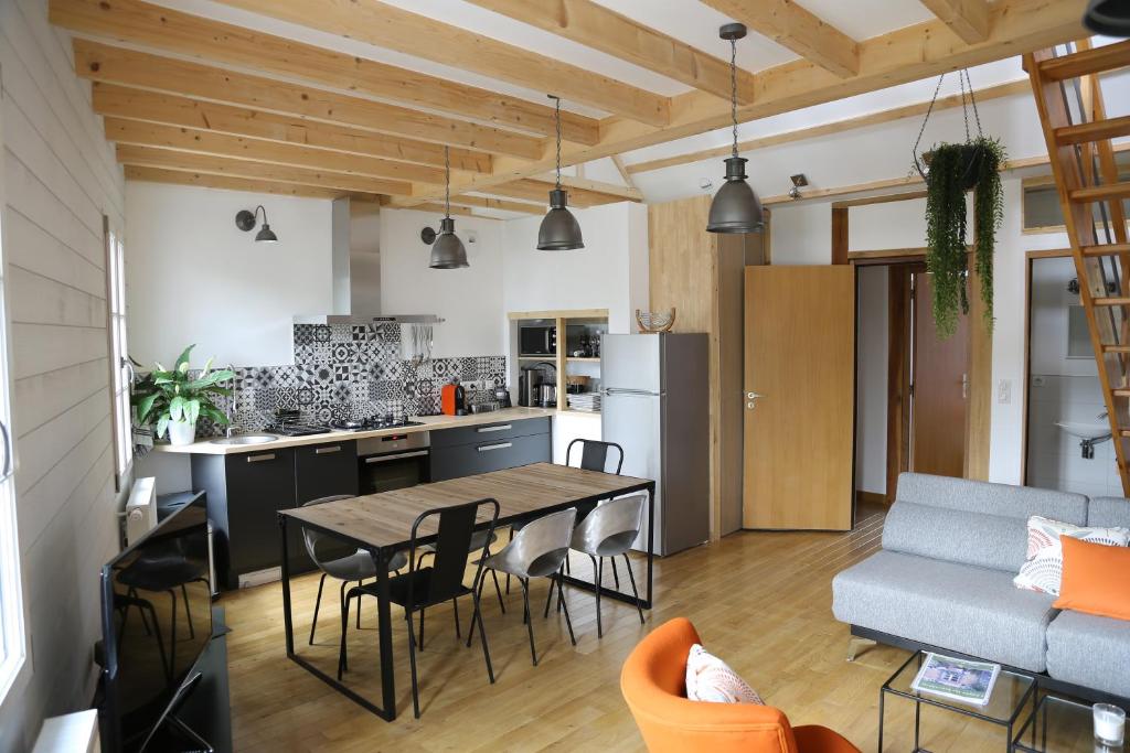 a kitchen and living room with a table and chairs at Loire Escale in Ancenis