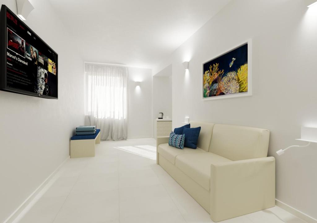 a white living room with a couch and a tv at Amalfi Suite Boutique Hotel in Amalfi