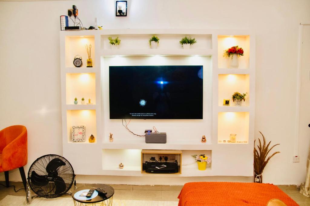 sala de estar con TV de pantalla plana en la pared en 1bed luxury Apartment Opebi, en Ikeja